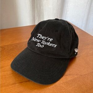 Black baseball hat “they’re New Yorkers too” bird collective